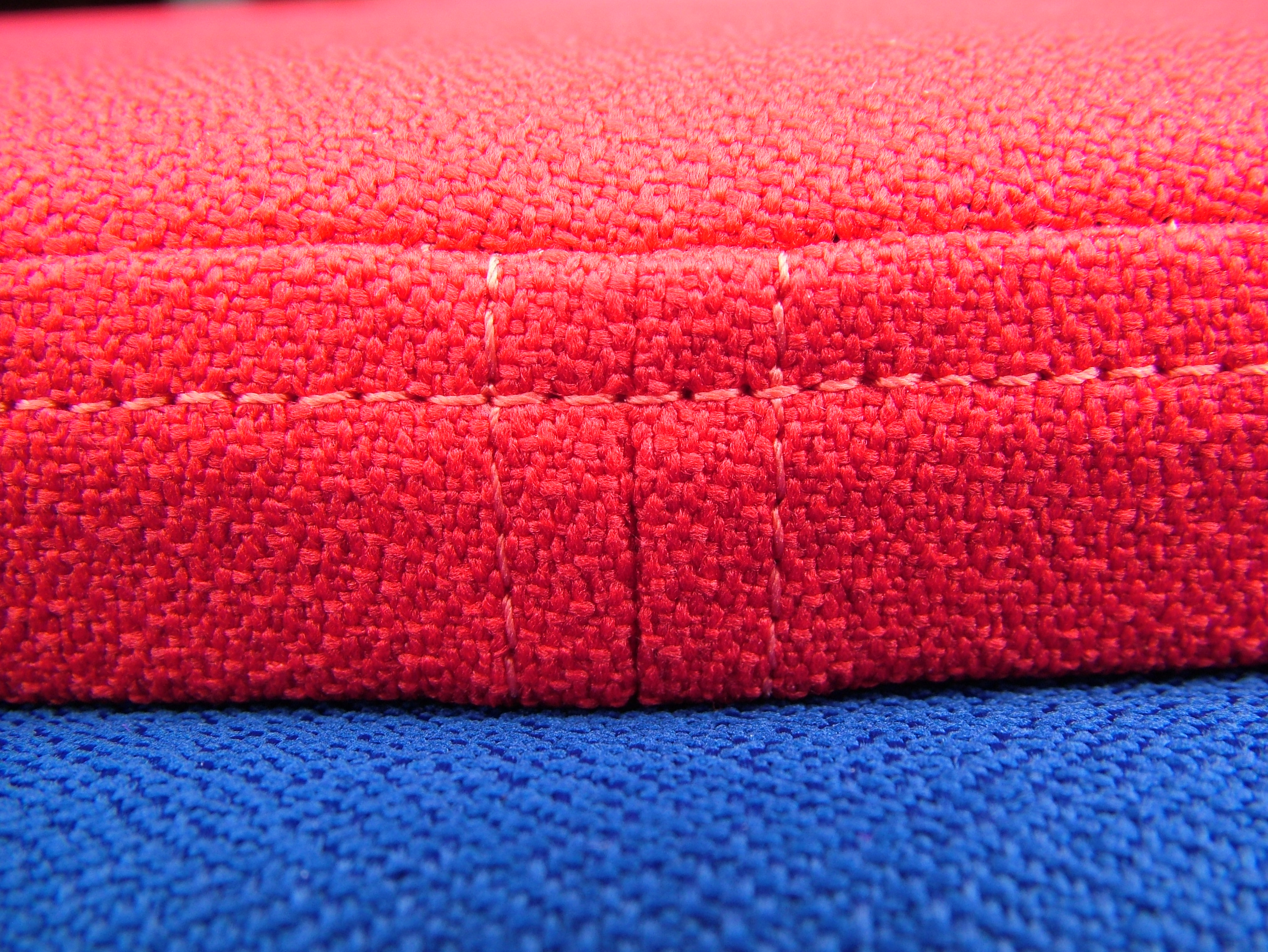 edge of tiles in red and blue showing stitched fabric