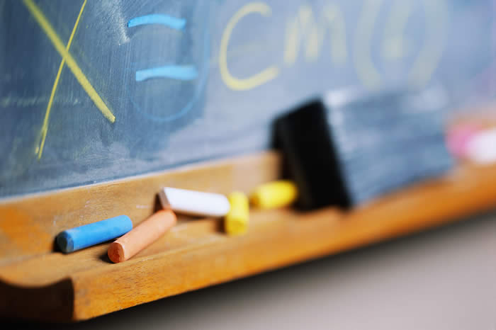 base of blackboard with coloured chalk and a rubber